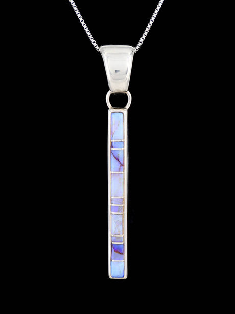 Silver pendant with blueish opal stones on a black background